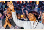 Audience members raising their hands in praise